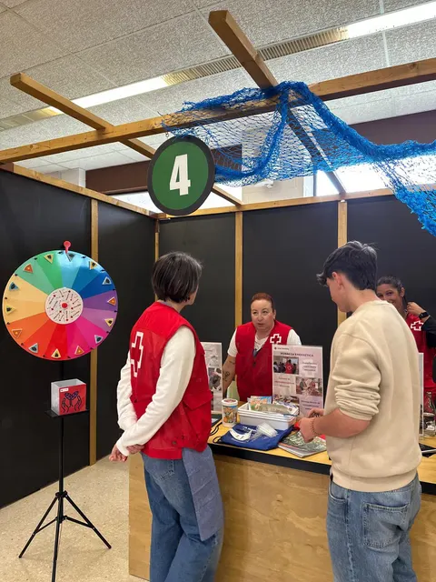 Stand con ruleta de xogo e voluntariado atendendo