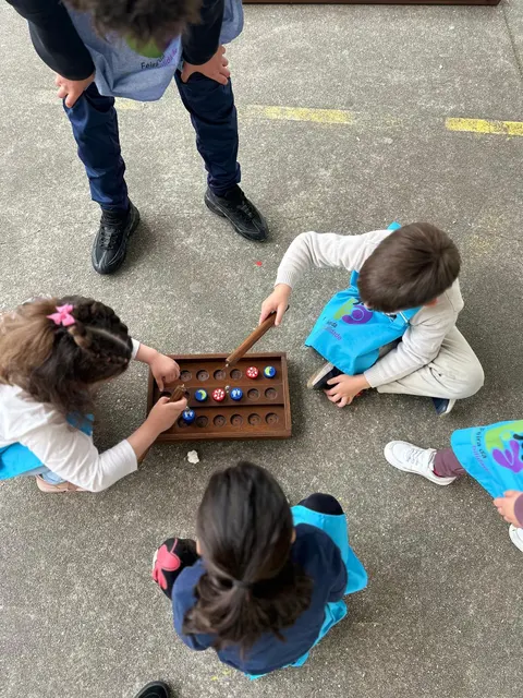 Nenas e nenos xogando a un xogo inclusivo no chan